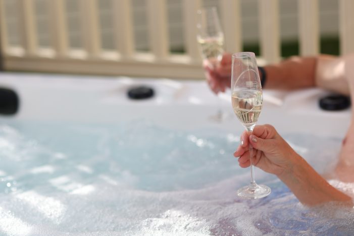 People drinking champagne in a hot tub